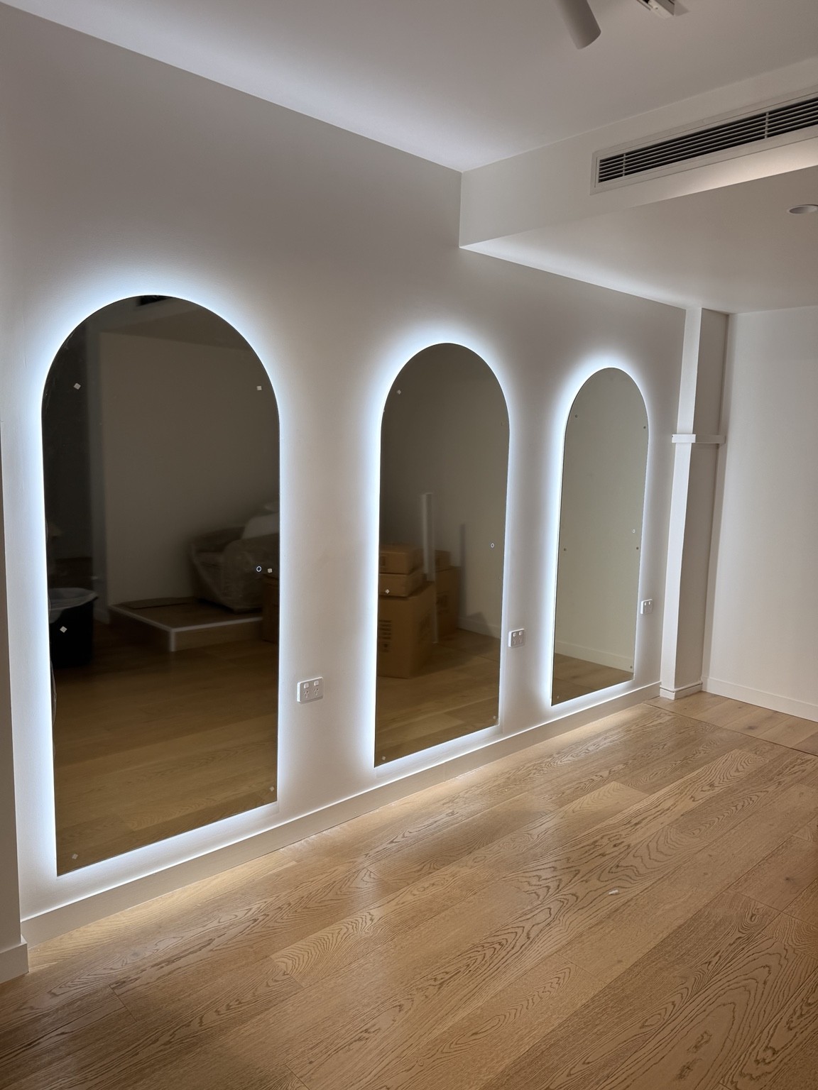 Three illuminated arched mirrors installed as a set